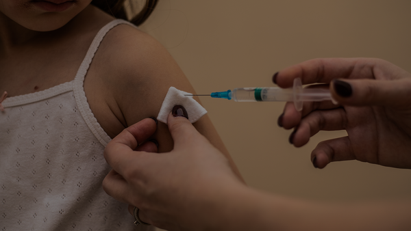 Girl receiving an injection from a healthcare professional.